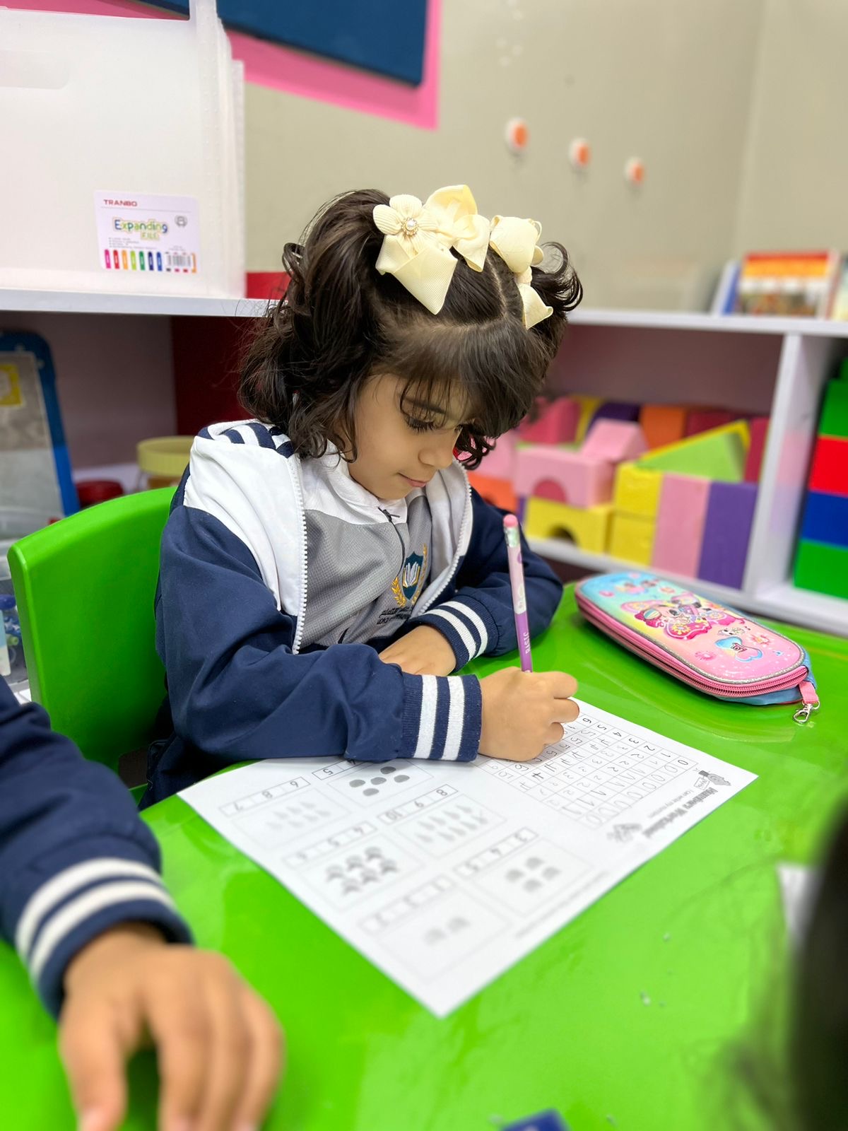 Teacher with kindergarten children in a colorful classroom